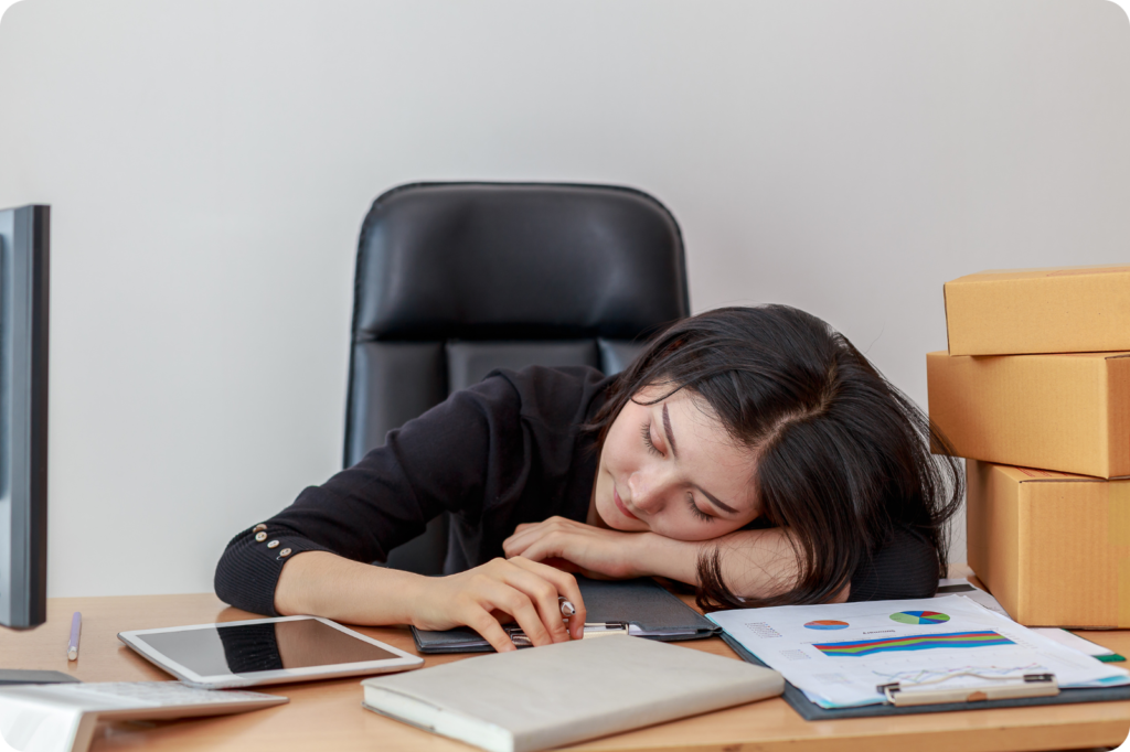 A woman sleeping at workplace, because of poor sleep Hygiene