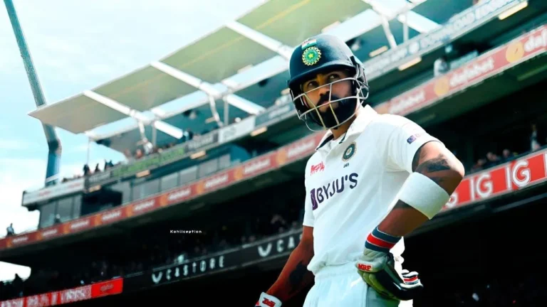 Virat Kohli in India’s white Test jersey and helmet, standing confidently with his bat under stadium lights, looking focused before taking strike.