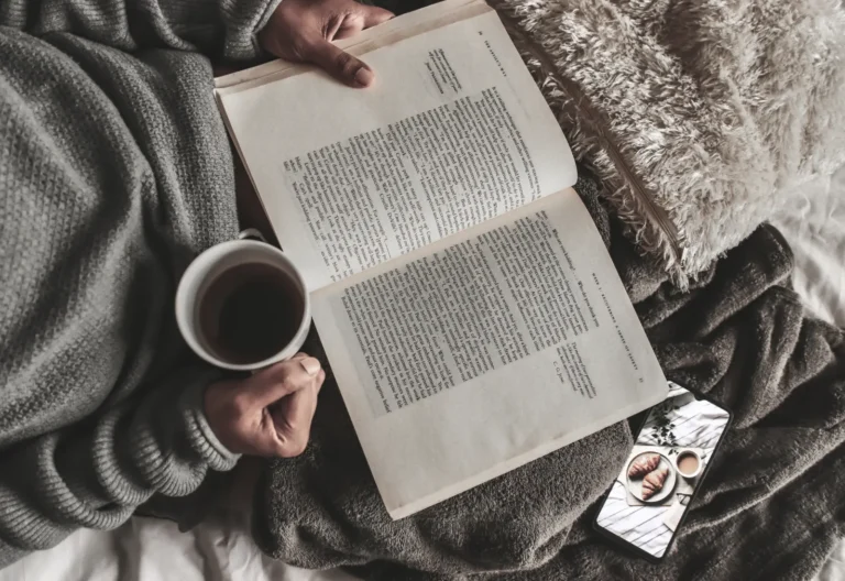 This image shows a person relaxing and decluttering their thoughts with some coffee and a book.