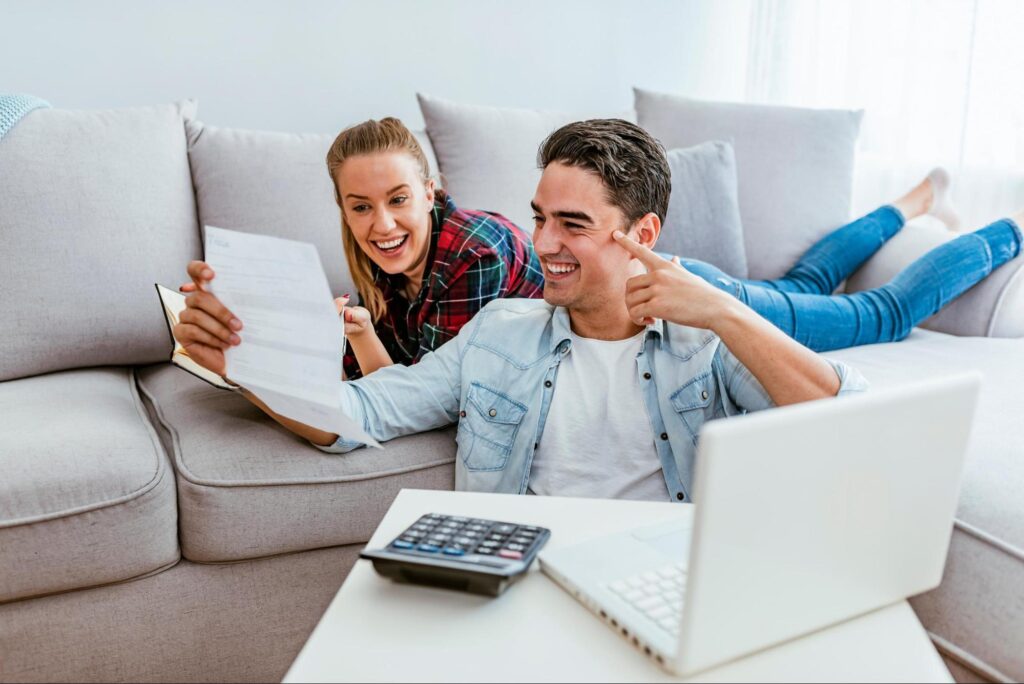 A man holding paper and women laying on a couch discussing things