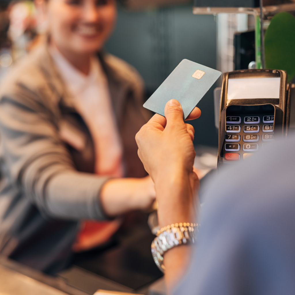 Person using a contactless card to make a payment at a card reader.